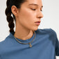 Model wearing Pilgrim's CHARM clover pendant, gold-plated, on a choker necklace, adding a stylish, lucky touch to her simple blue T-shirt ensemble.