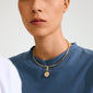 Close-up of a person wearing Pilgrim's CHARM gold-plated peace dove pendant on a chunky torque choker, embodying calm and personal style.