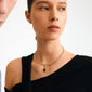 Young woman wearing Pilgrim's CHARM medallion pendant, gold-plated, showcasing an oval Tiger Eye stone on a slim choker, embodying timeless elegance and personal strength.