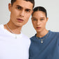 Models wear silver CHARM peace dove pendants by Pilgrim, showcasing minimalist fashion with a focus on calm and harmony through recycled, rustic design.