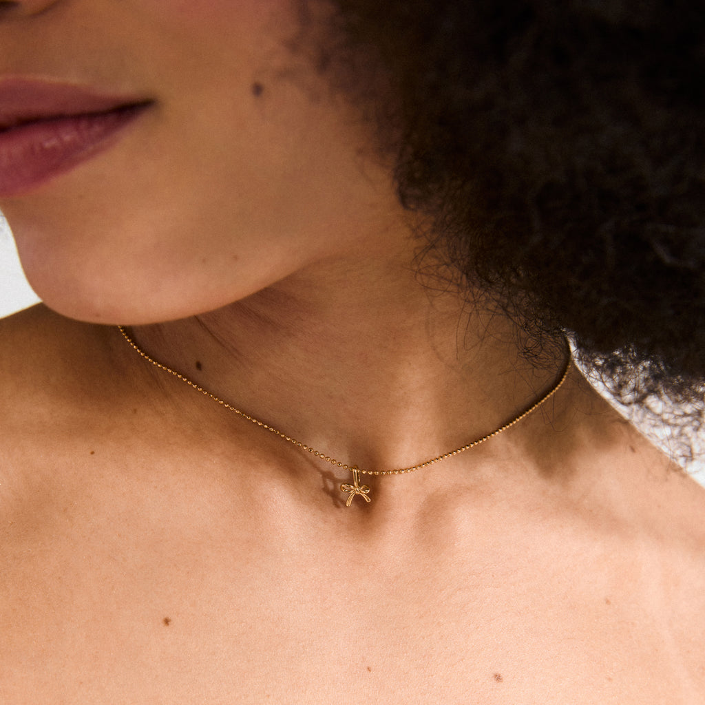 Gold-plated CHARM mini bow pendant, perfect for earrings, necklaces, or bracelets. Water-resistant and eco-friendly, made from 99% recycled materials. Ideal for a stylish, personalized look.