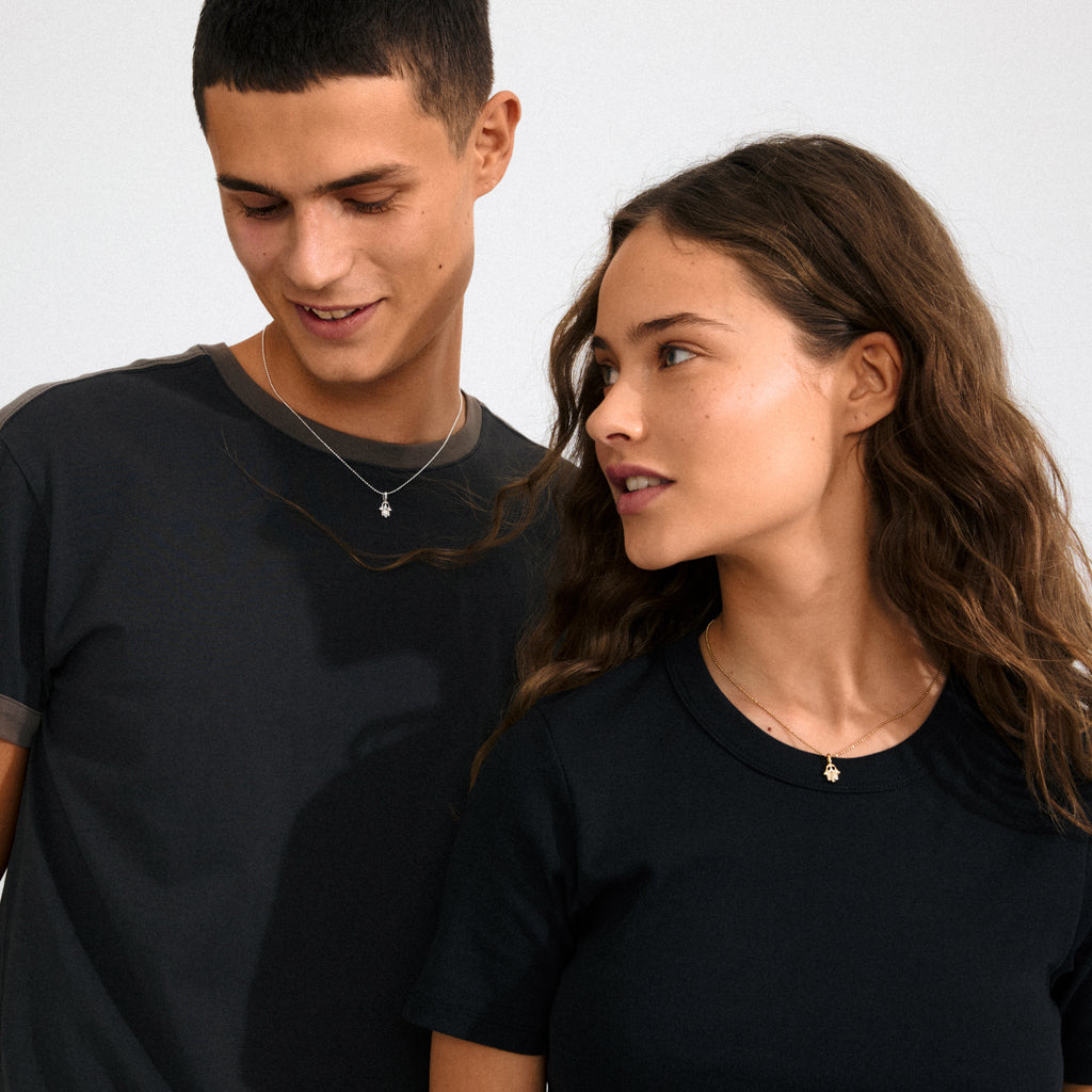 Gold-plated CHARM mini hamsa pendant with sparkling crystals, showcasing intricate hand detail. Ideal for personalized styling, crafted from 98% recycled, water-resistant materials.
