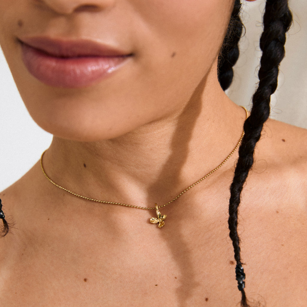 Gold-plated mini flower pendant charm, perfect for bracelets, necklaces, or hoops. Made from 99% recycled material, water-resistant, offering a sweet, nature-inspired style.