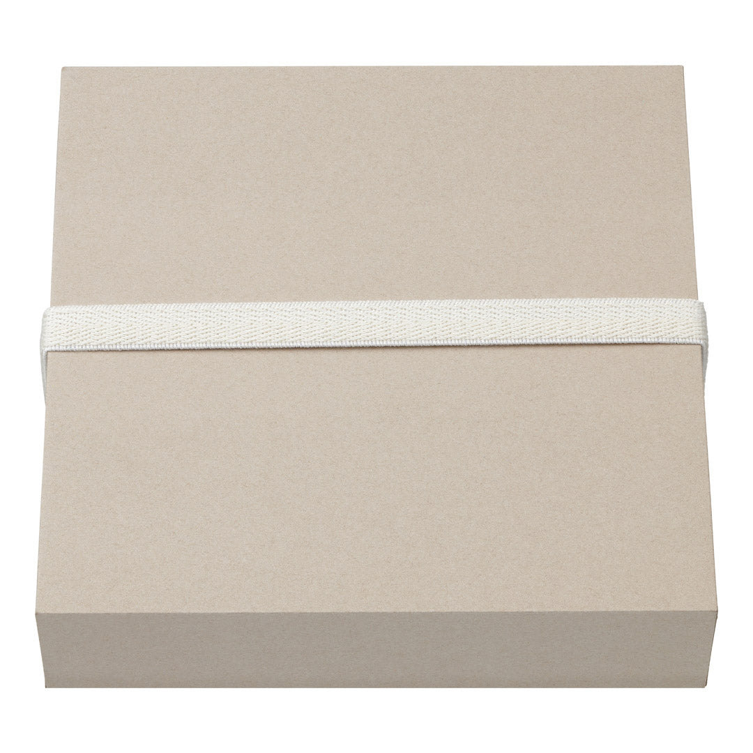 Gift box, XL, W165 x H165 x D45 mm, featuring a minimalist design with a white elastic band securing the light-brown box, perfect for stylish gifting.