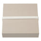 Gift box, XL, W165 x H165 x D45 mm, featuring a minimalist design with a white elastic band securing the light-brown box, perfect for stylish gifting.