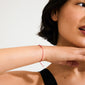 Woman wearing the APRIL birthstone bracelet—a delicate red cotton cord with Rock Crystal, symbolizing positivity and clarity, perfect for minimalist style enthusiasts.