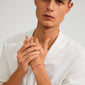 Man wearing the JANUARY birthstone bracelet, featuring a red garnet on a delicate red cotton cord with adjustable knot closure, highlighting minimalist boho style.