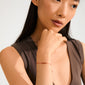 JULY birthstone bracelet featuring a delicate red cotton cord and Red Agate, worn by a woman with her hand on her chin.