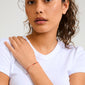 Woman wearing the MAY birthstone bracelet, featuring a red cotton cord and Green Agate stone, symbolizing harmony and balance.