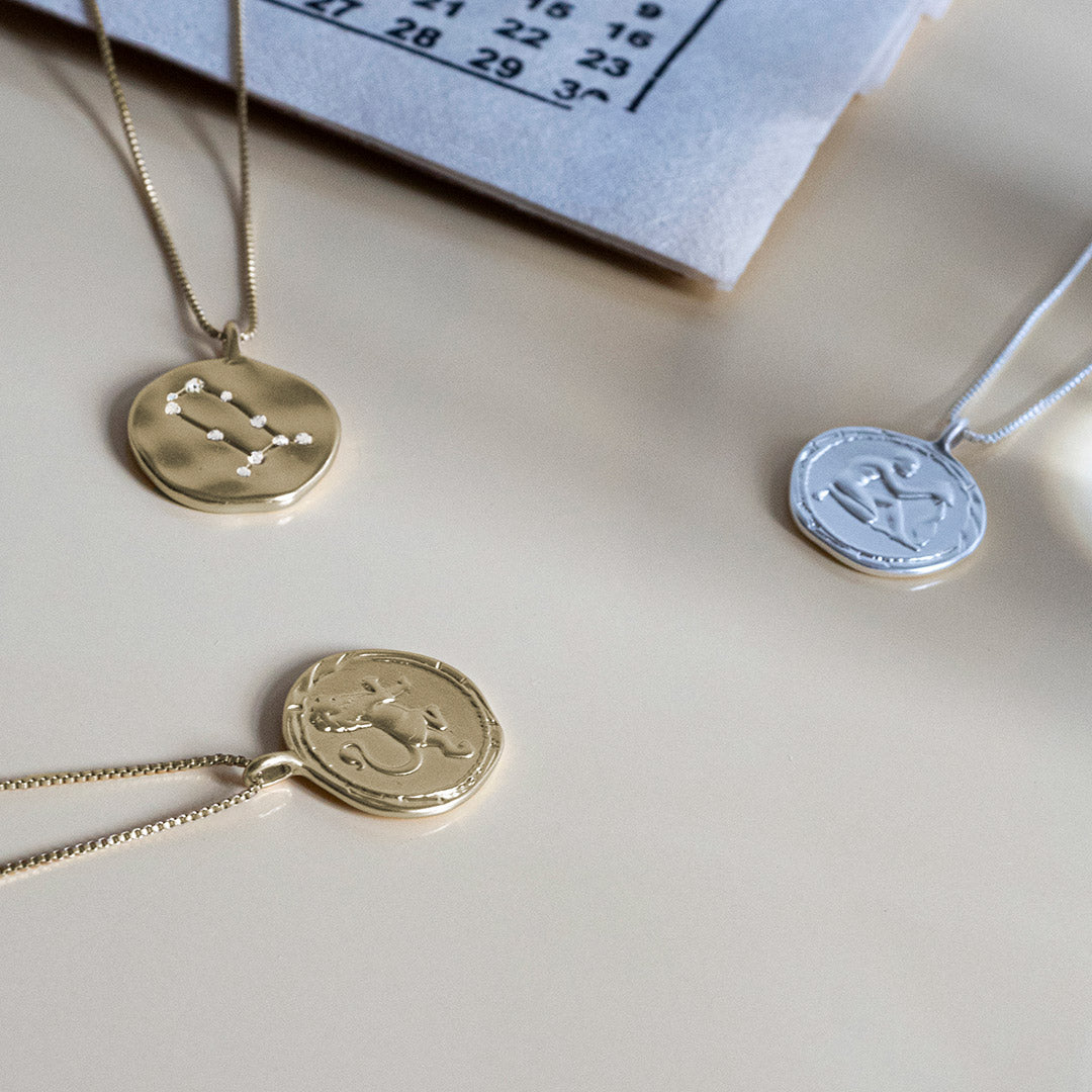 LEO Zodiac Sign Coin Necklace, gold-plated, featuring a double-sided pendant with zodiac motif and constellation in crystals, adjustable chain length for personalized fit.