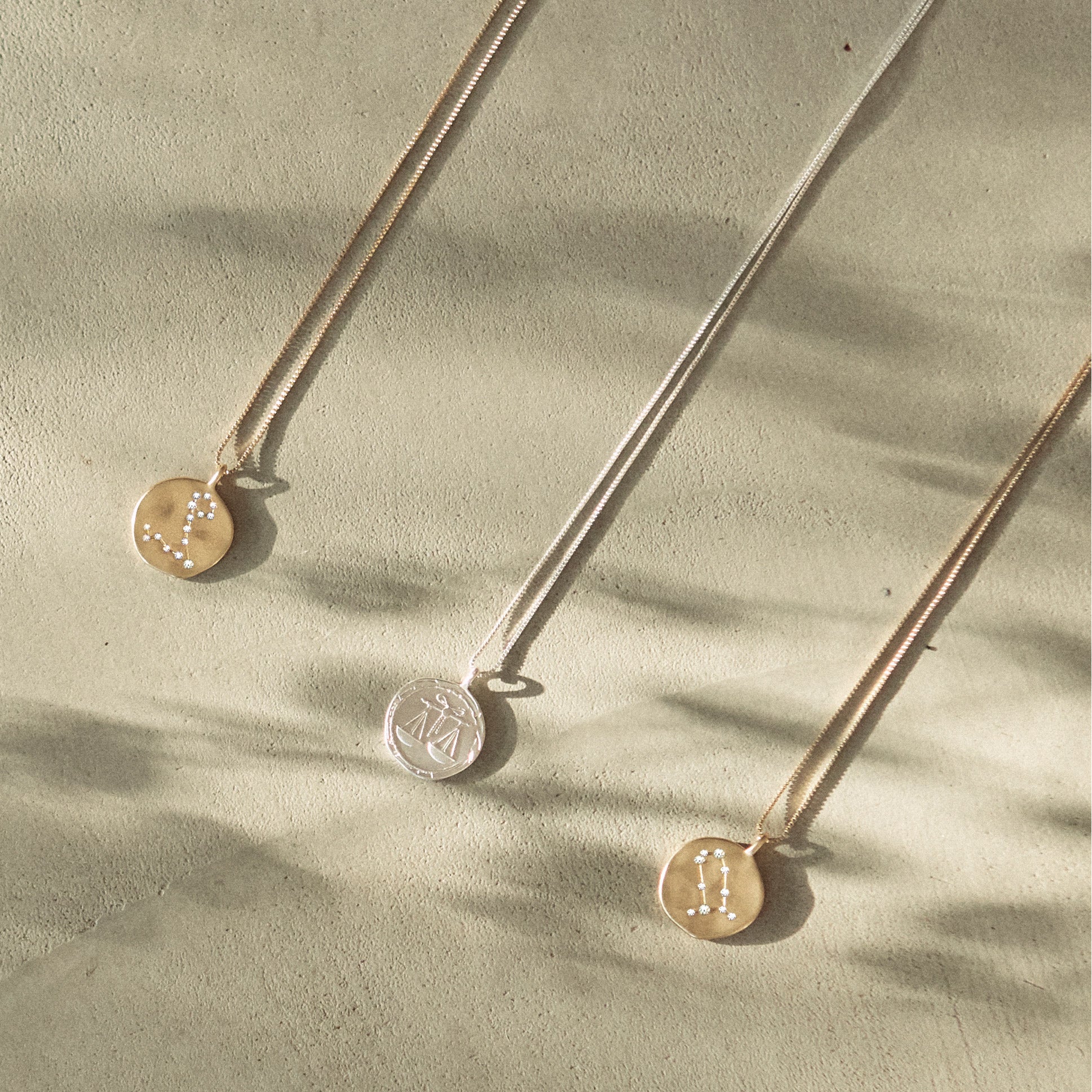 LIBRA Zodiac Sign Coin Necklace, silver-plated, with a double-sided pendant featuring a zodiac motif and crystal constellation, displayed on a concrete surface.