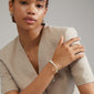 Woman wearing SOULMATES bracelet mint/gold-plated, showcasing semi-precious amazonite and tiger eye stones, highlighting Pilgrim's blend of courage and confidence.