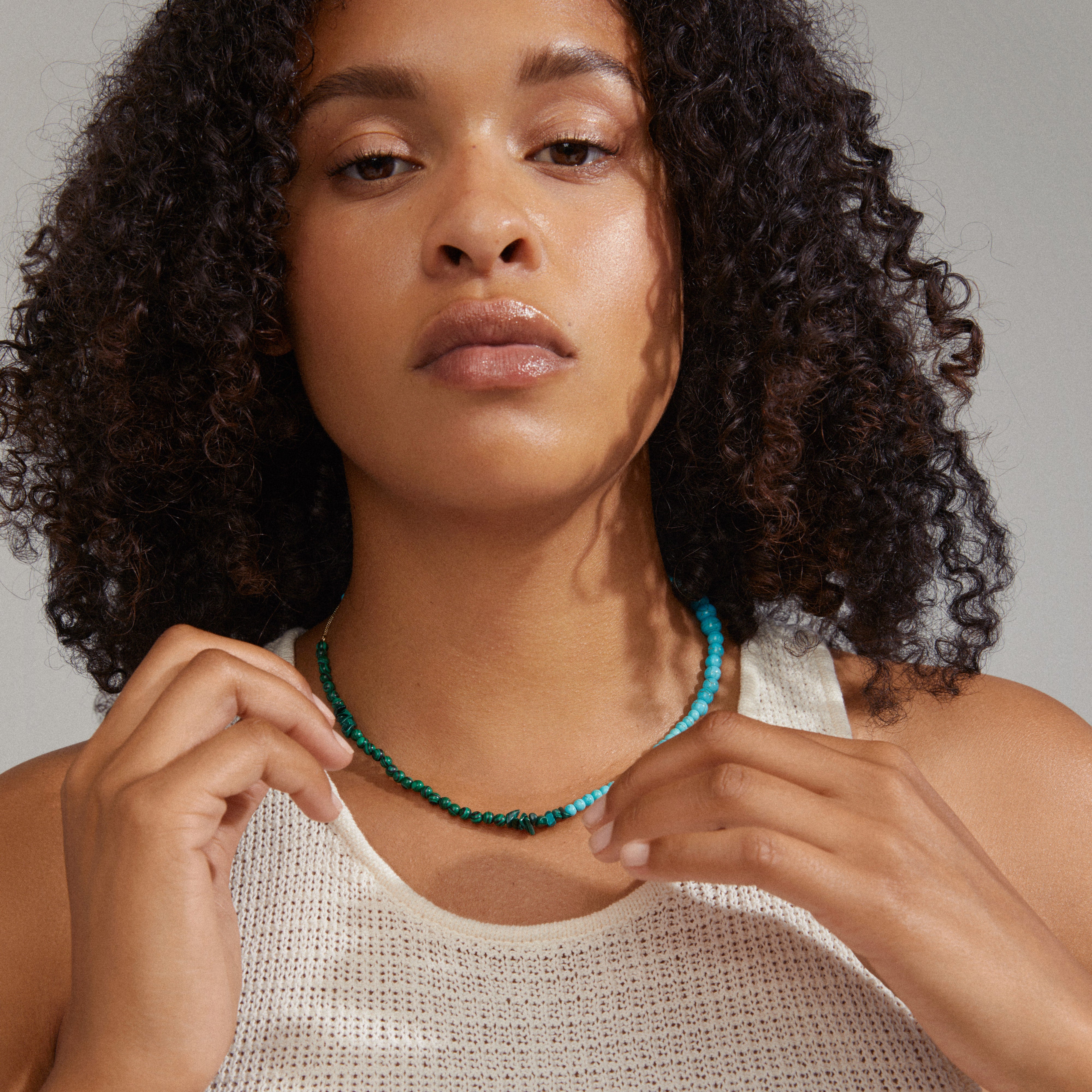 Woman wearing Pilgrim's SOULMATES necklace in turquoise and green, featuring an asymmetrical design with unique beads, embodying balance and power.