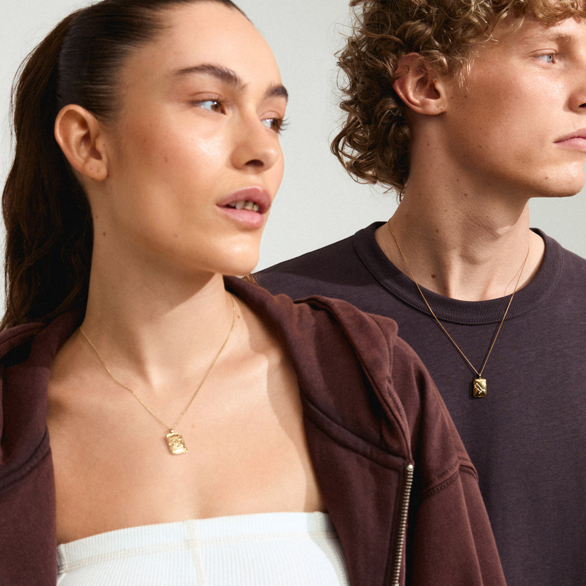 GEMINI Zodiac Sign necklace, gold-plated, featuring a dual-design pendant with a Gemini motif and constellation, worn by a man and woman.