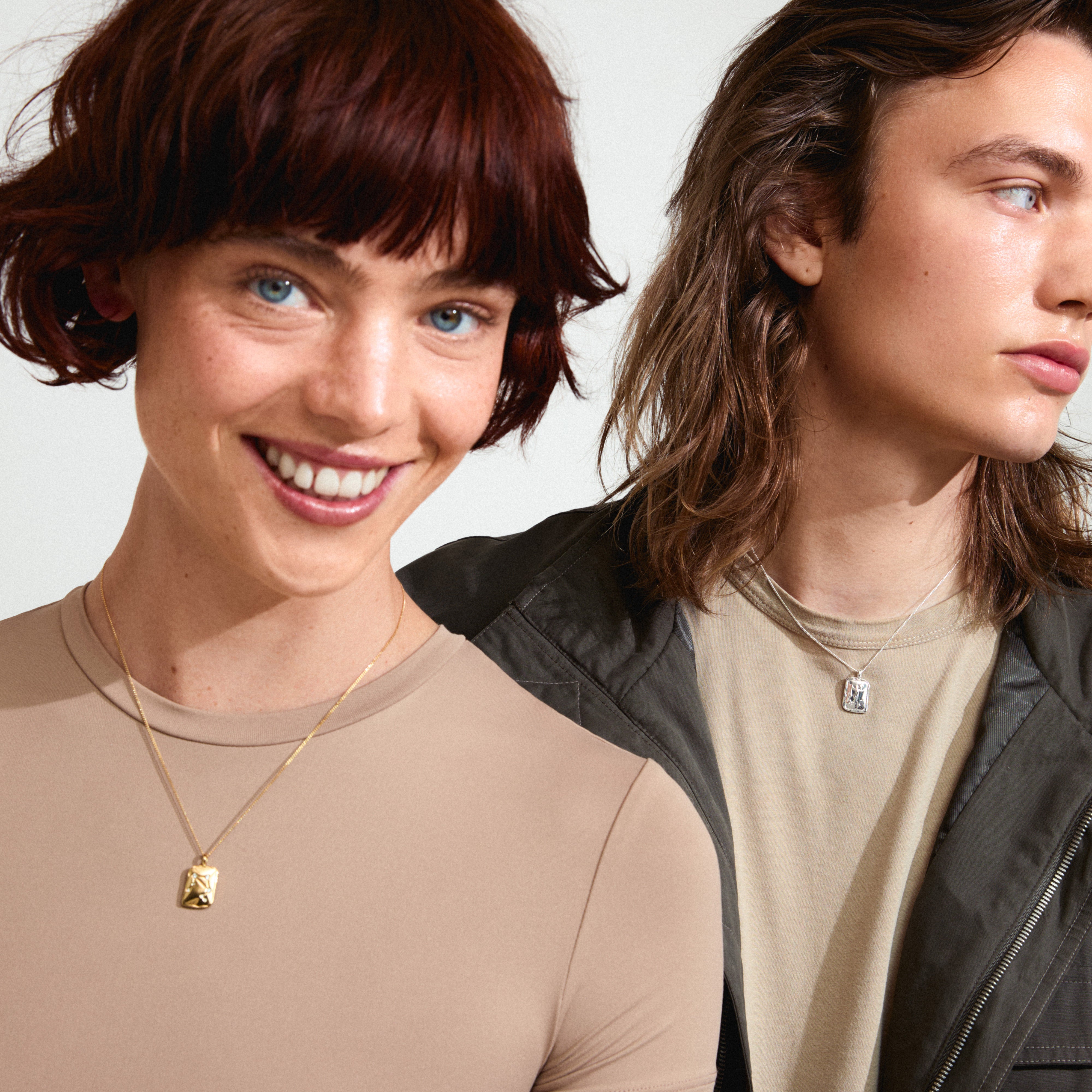 LIBRA Zodiac Sign necklace, gold-plated with a square coin pendant featuring dual designs, worn by a smiling woman.