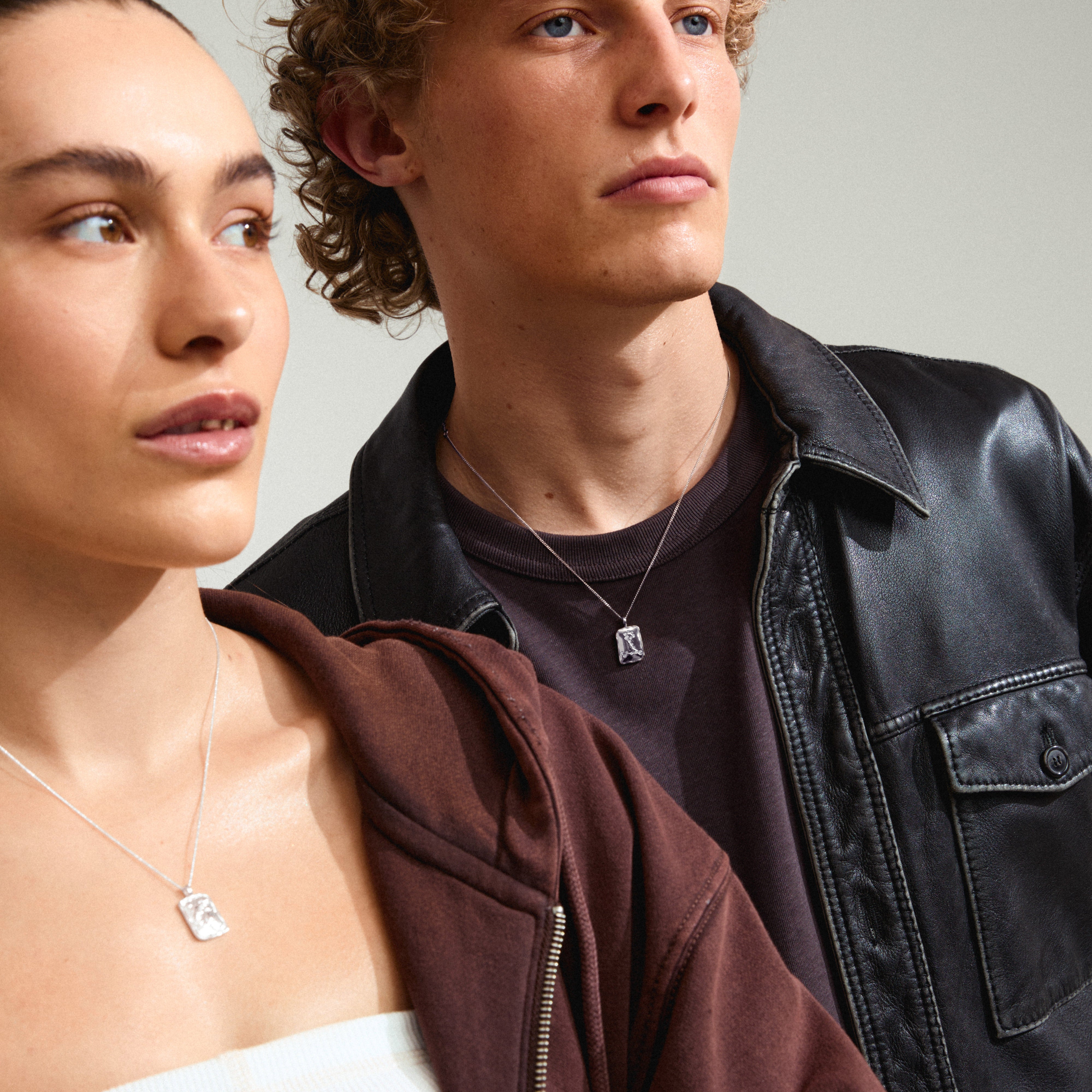 PISCES Zodiac Sign necklace, silver-plated, with a square coin pendant featuring a Pisces motif and sparkling constellation, worn by a woman.