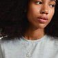 Woman wearing the CANCER Zodiac Sign necklace, silver-plated, featuring a square coin pendant with a crab motif and sparkling constellation design by Pilgrim.
