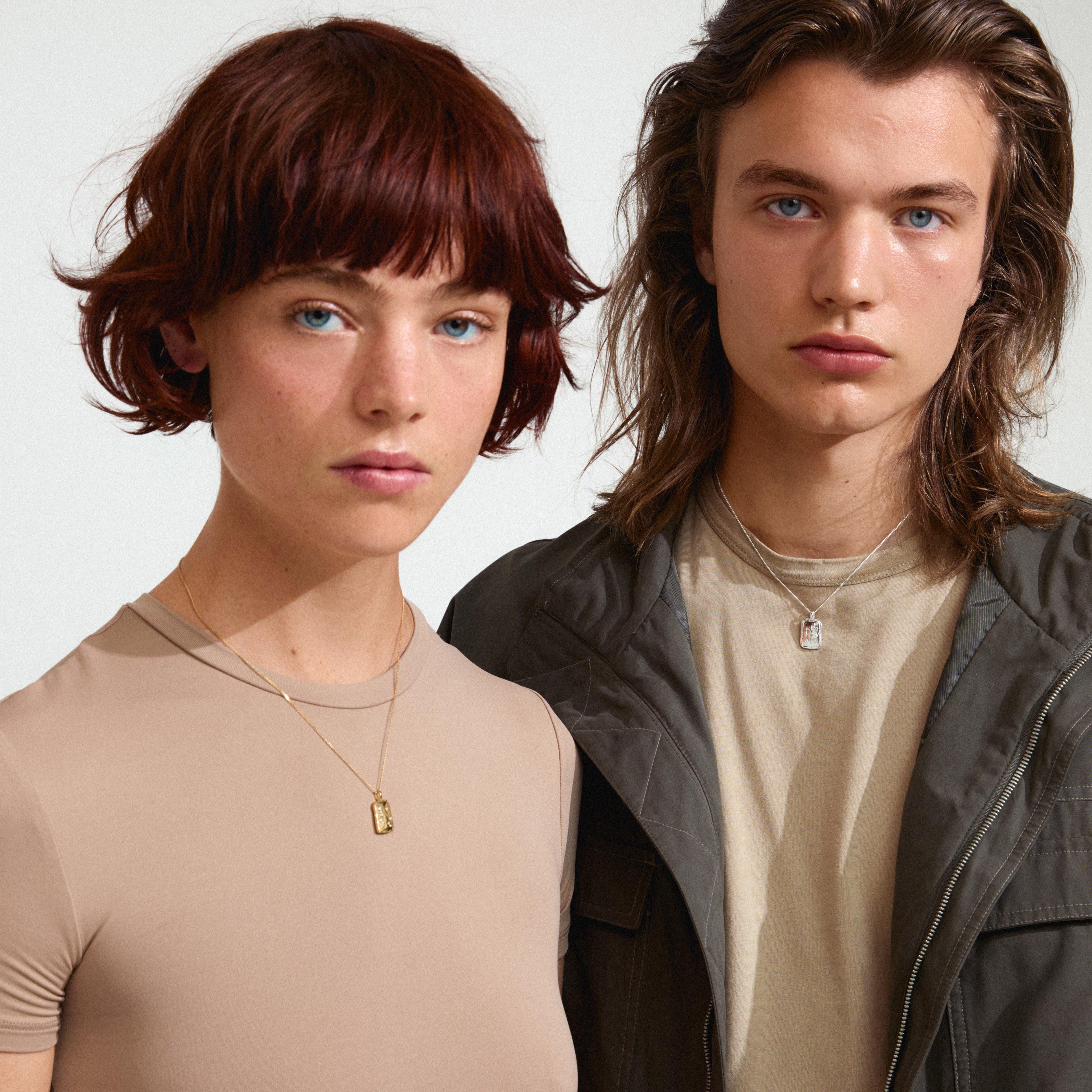 Two individuals showcasing the LIBRA Zodiac Sign necklace, silver-plated, featuring a dual-design pendant with zodiac motifs and sparkling constellation details.