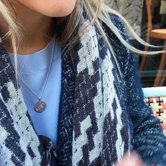 LEO Zodiac Sign Coin Necklace: Silver-plated with a round pendant featuring Leo constellation crystals, worn by a woman, epitomizing Pilgrim's Scandinavian craftsmanship.