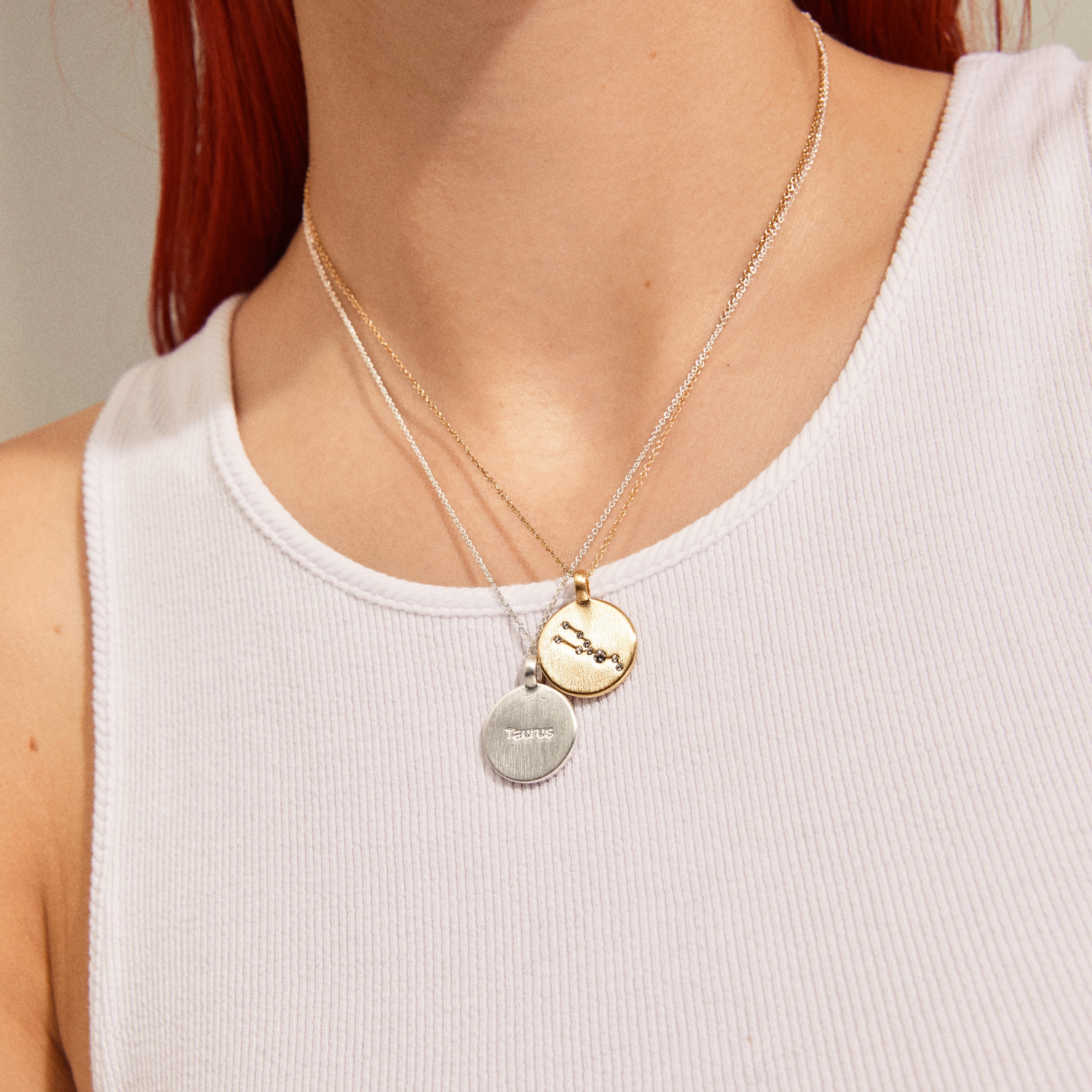 SCORPIO Zodiac Sign Coin Necklace, silver-plated, featuring a round pendant with crystal stones, worn by a person in a white tank top.