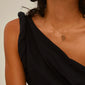 LOVE TAG, DAD necklace gold-plated on a model, featuring a delicate gold chain with a rectangular pendant engraved with DAD, showcasing Pilgrim's Scandinavian craftsmanship.