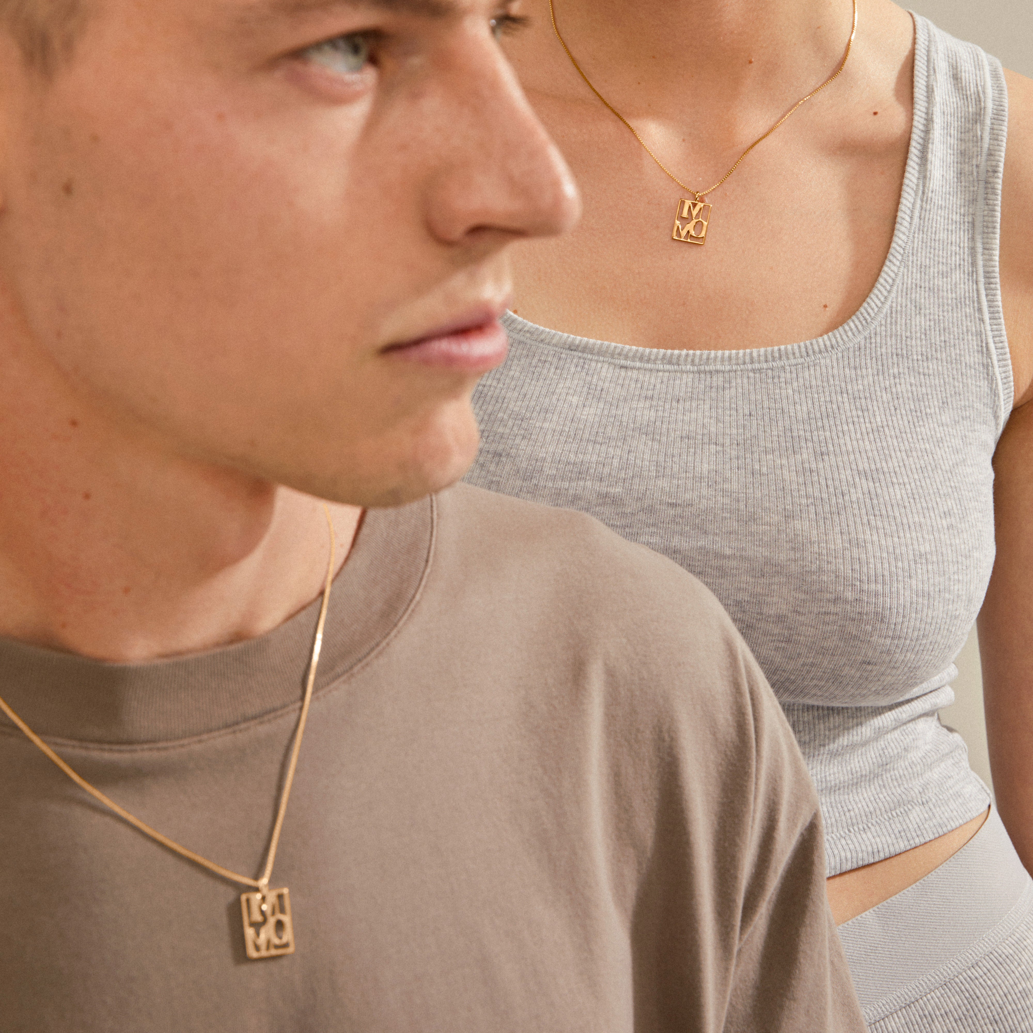 LOVE TAG, MOM gold-plated necklace featuring a square pendant with MOM, worn by a woman, symbolizing love, suitable for layering, from Pilgrim.