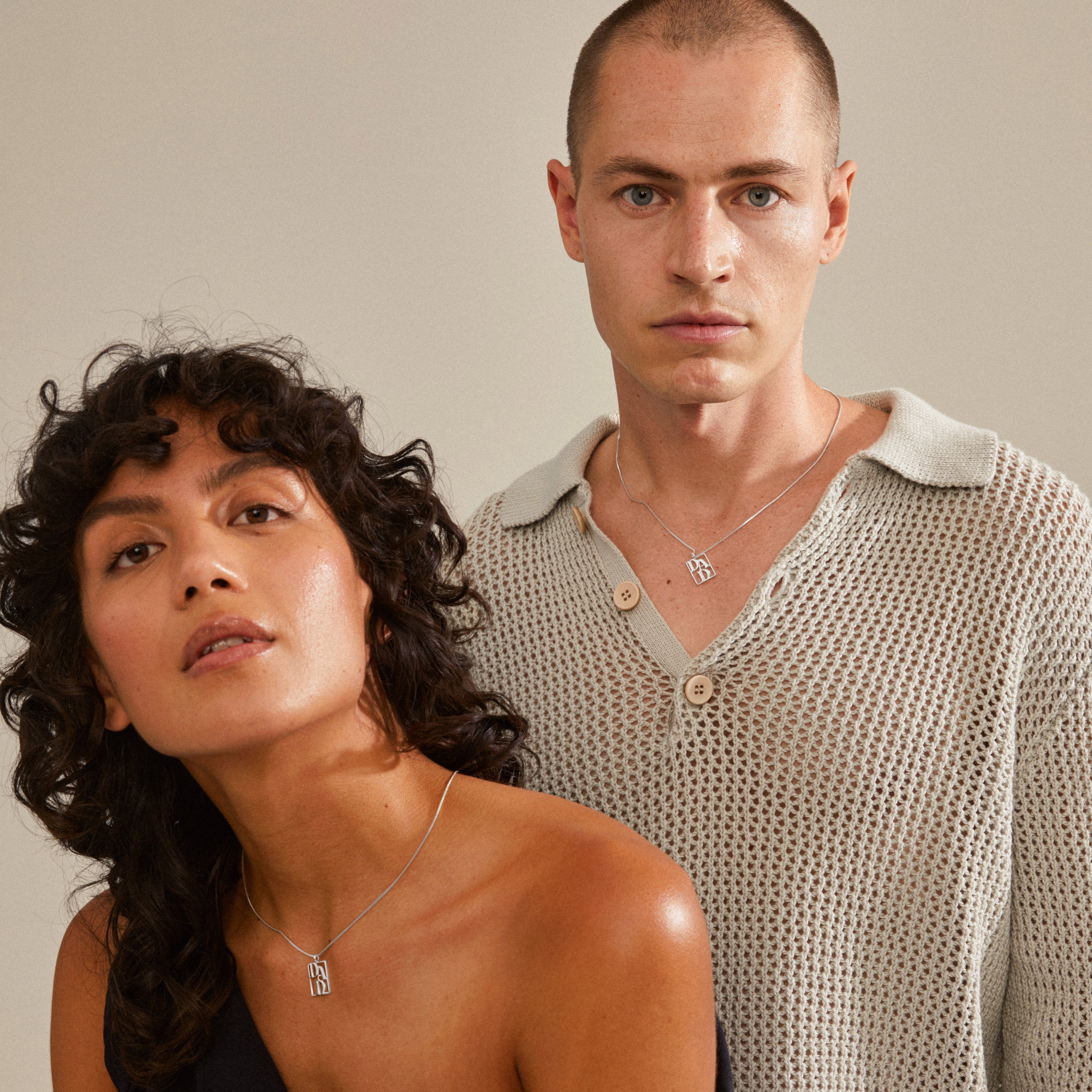 LOVE TAG, DAD silver-plated necklace on man and woman, showcasing Pilgrim's handmade, timeless Danish design with a square pendant engraved with DAD.