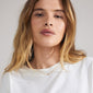 Gold-plated FAITH necklace on a woman, featuring a cursive script pendant, embodying a sleek, genderless design ideal for layering and personal expression.