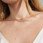Close-up of a woman's neck adorned with a gold-plated 'HOPE' necklace, featuring a cursive pendant and chain extension.