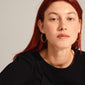 LAYLA large gold-plated hoop earrings with click clasp, worn by a red-haired woman, showcasing their elegant, timeless design as part of Pilgrim's collection.