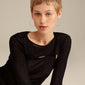 Woman wearing TILLY large hoop earrings, gold-plated, showcasing their sleek, airy design and large 50 mm size, emphasizing elegance and style.