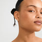 Young woman wearing IMOGEN crystal leaf earrings gold-plated, featuring delicate twig design with tiny gemstone leaves, highlighting Pilgrim’s blend of timeless elegance and trendiness.