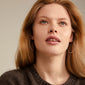 TILLY large hoop earrings, silver-plated, worn by a woman in a grey sweater, showcasing their sleek and feminine design.