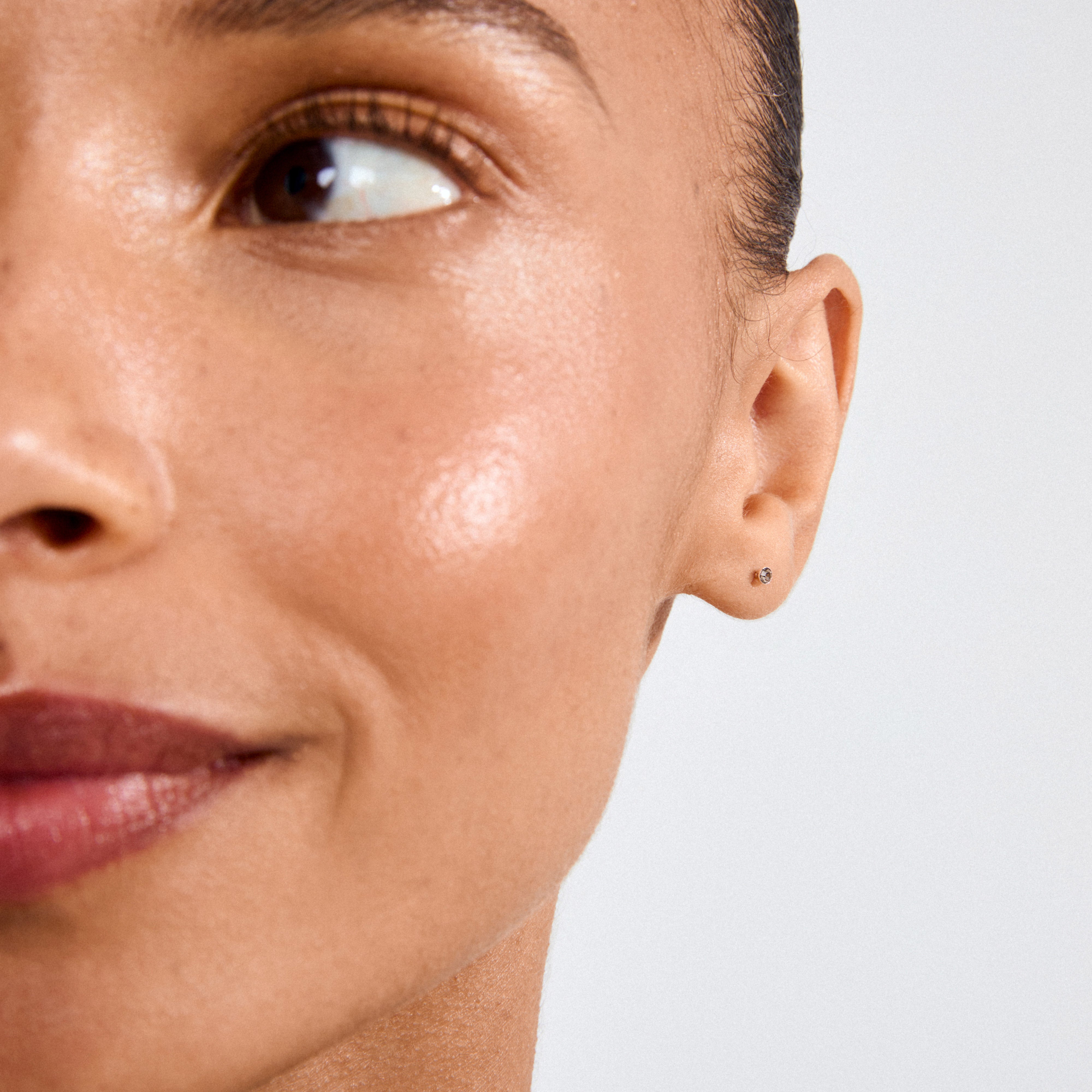 Close-up of ear with YANA micro crystal earstuds grey/silver-plated, featuring a subtle Preciosa crystal in a silver setting, reflecting Pilgrim's blend of trend and timeless style.