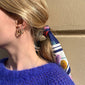 Woman wearing ROBERTA crystal semi-hoops gold-plated, showcasing medium-sized hoops with clear crystals, embodying Nordic cool simplicity and exclusivity from Pilgrim.