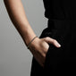 LUCIA crystal bracelet gold-plated on wrist, showcasing sparkling crystals with an elegant, modern adjustable closure, worn by a person with hand in pocket.