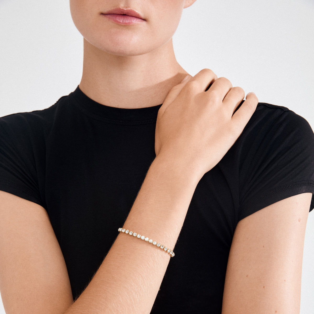 Person wearing LUCIA crystal bracelet gold-plated, adorned with sparkling Preciosa crystals, showcasing elegant simplicity and modern style.