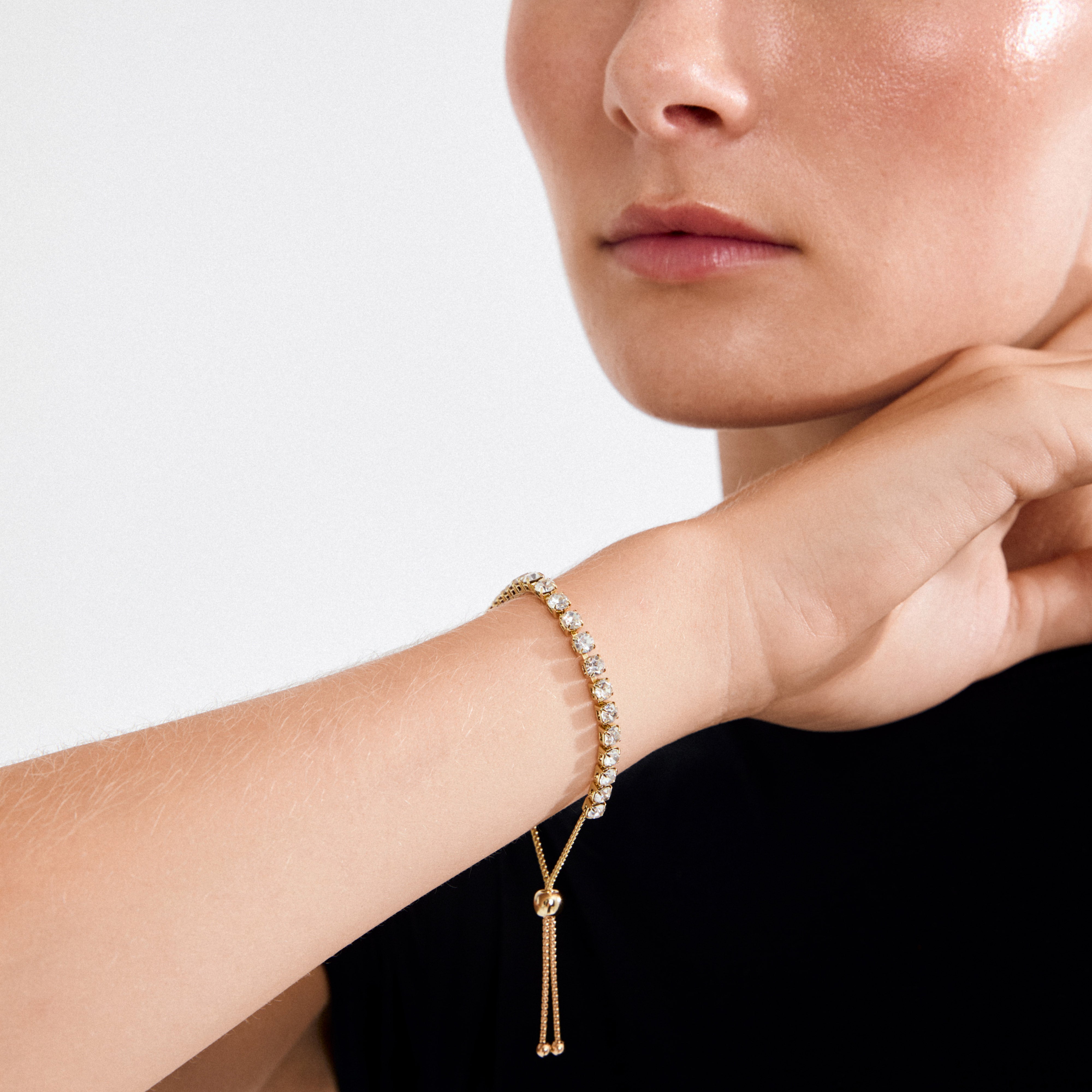 LUCIA crystal bracelet gold-plated on a woman's wrist, featuring sparkling Preciosa crystals and an adjustable sliding clasp, highlighting its elegant and versatile design.