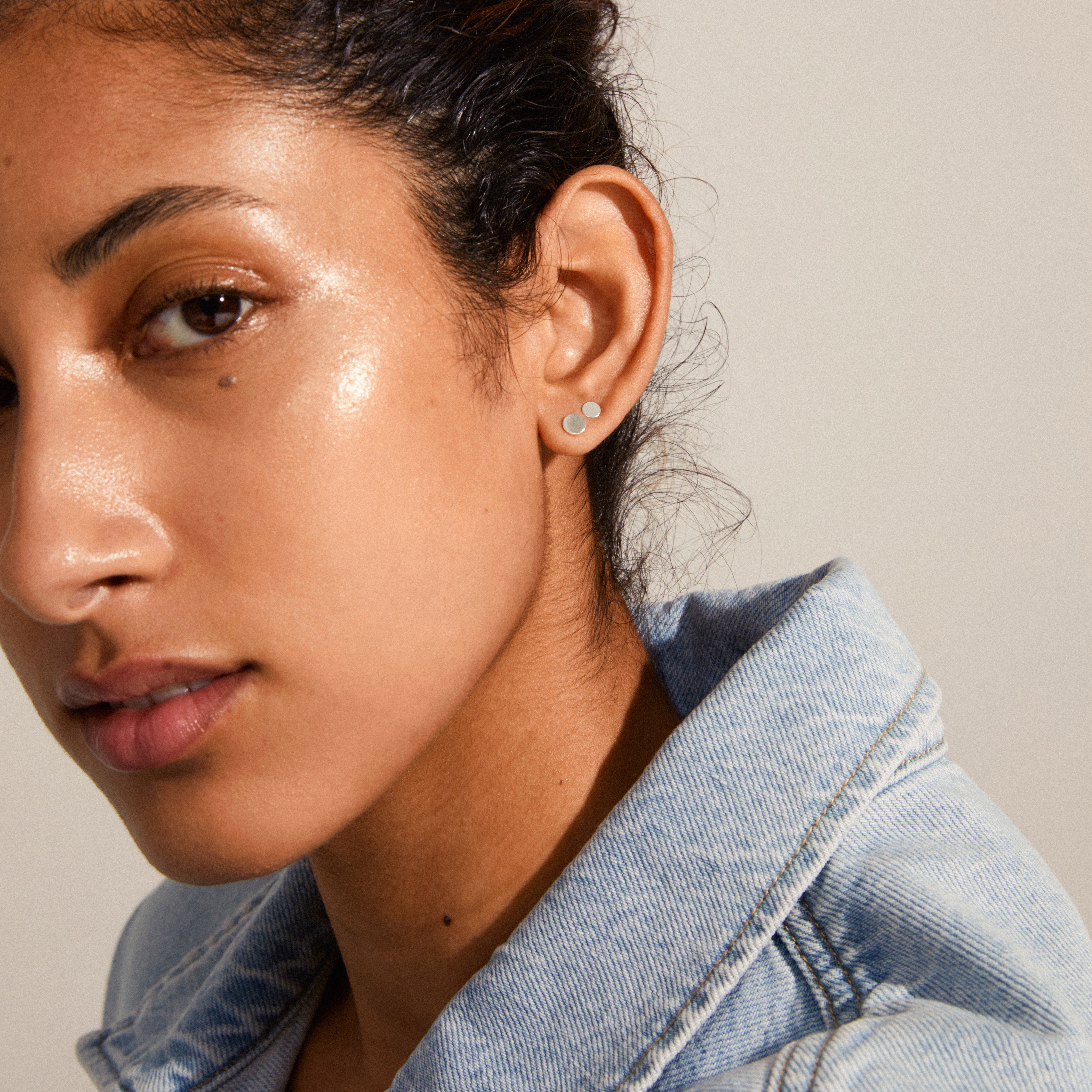Close-up of a woman wearing the NORMA 3-in-1 silver-plated earrings set, showcasing minimalist studs for a versatile, stylish look.