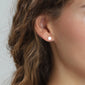 Close-up of a woman's ear wearing the NORMA 3-in-1 silver-plated earrings set, featuring minimalist studs in three sizes for versatile styling.