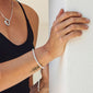 LUCIA crystal bracelet silver-plated on wrist, featuring sparkling crystals and an adjustable, modern closure, worn by a person in a black tank top.