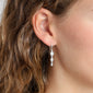 LUCIA crystal earrings silver-plated on a woman's ear, featuring three sparkling crystals in a row, perfect for adding glam to any outfit.