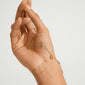 Hand holding ANET crystal bracelet gold-plated, featuring cross, anchor, heart charms, and tiny crystals, symbolizing faith, hope, and love in a delicate design.
