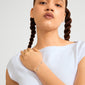 Young woman wearing the ANET crystal bracelet silver-plated, featuring a delicate cross charm and crescent accent, embodying faith, hope, and love with Preciosa crystals.