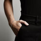 A person wearing a black shirt showcases the PARISA flat link chain bracelet, silver-plated, with its reflective texture elegantly draping the wrist.