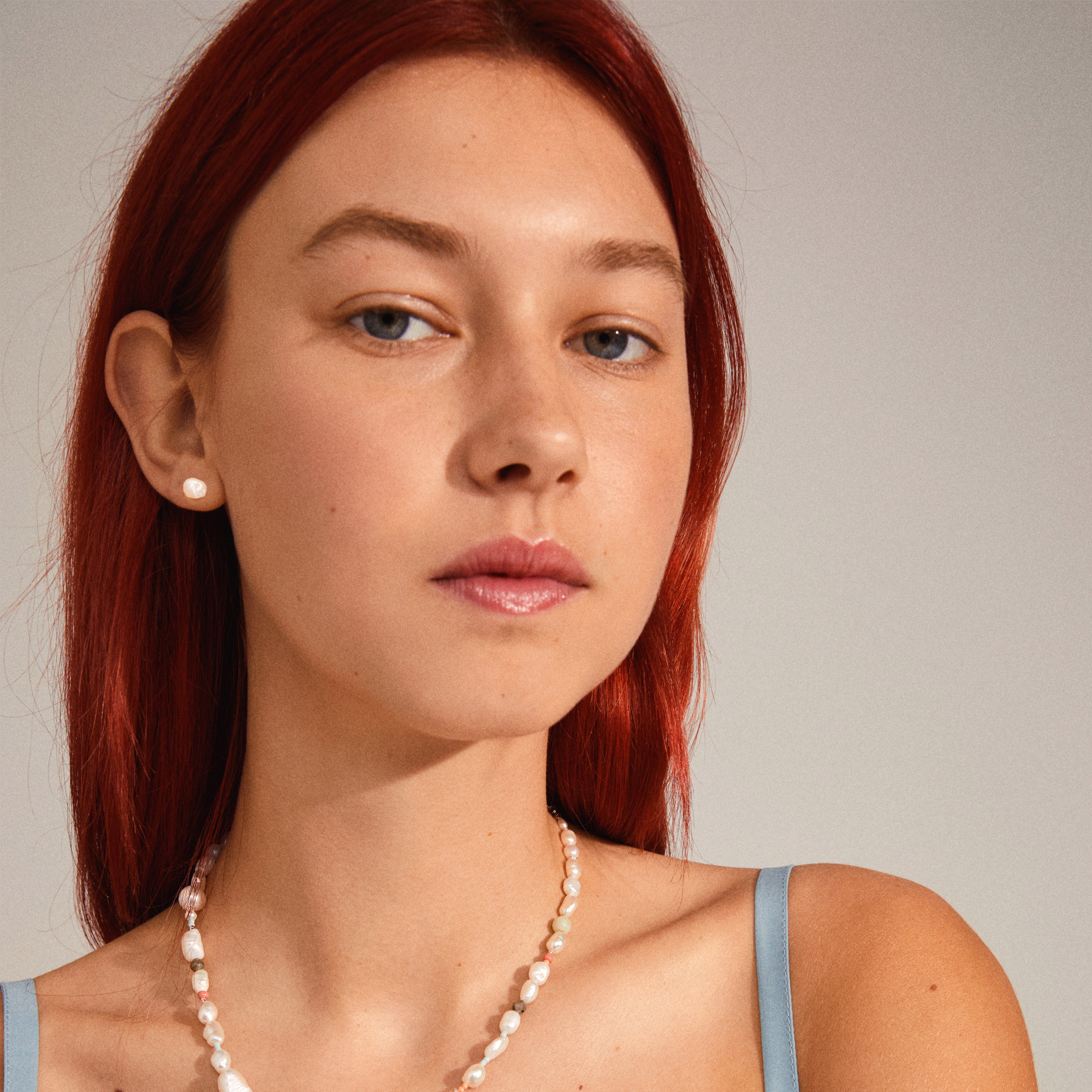 EMORY freshwater pearl earrings displayed on a woman with red hair, highlighting their timeless elegance and versatility for both casual and glamorous styles.