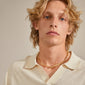 Blonde man wearing Pilgrim's RAELYNN gold-plated necklace with organic, handcrafted links, highlighting Scandinavian design and style.