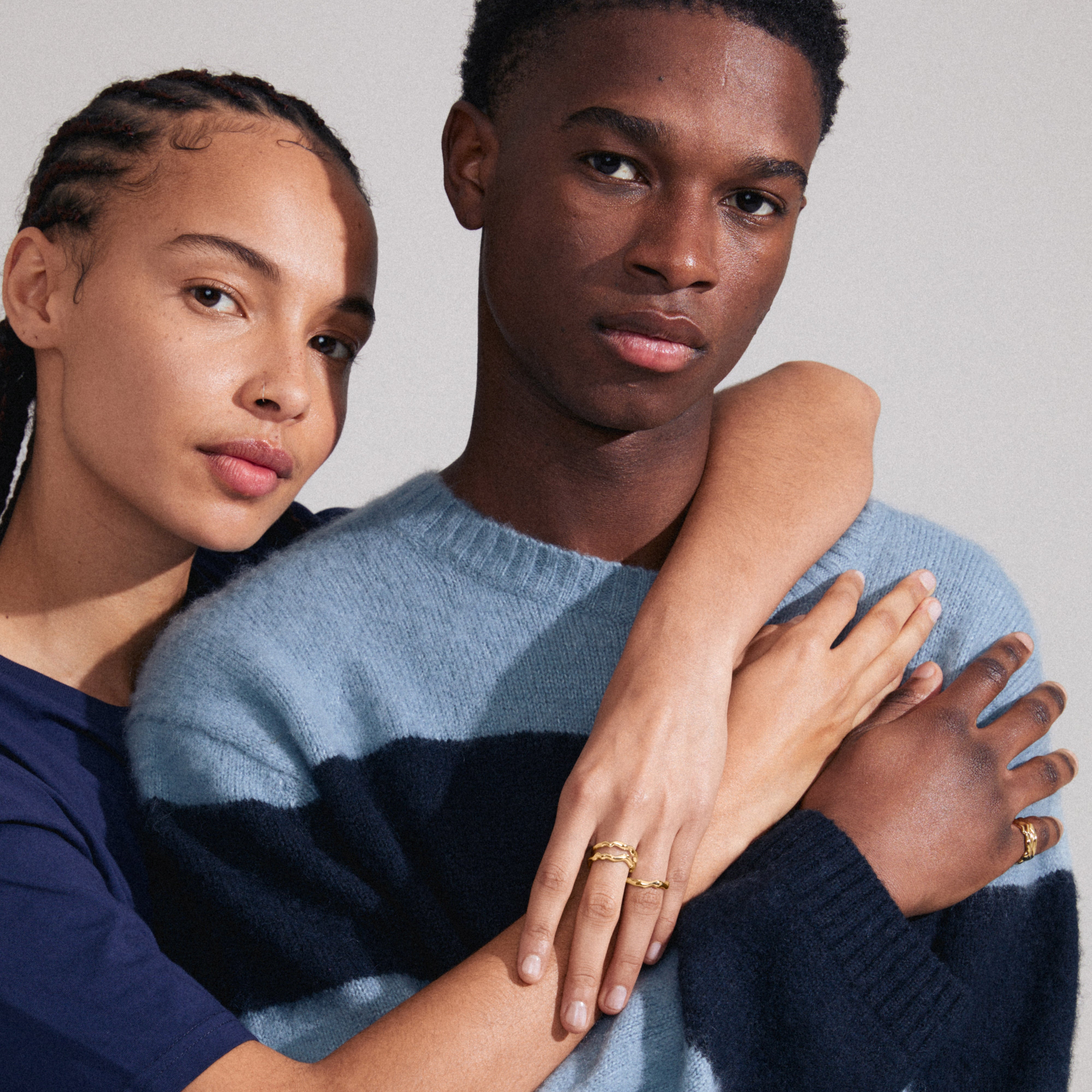 PENELOPE gold-plated rings with wavy design, worn by a couple. Adjustable and made from recycled materials for an eco-friendly style statement.