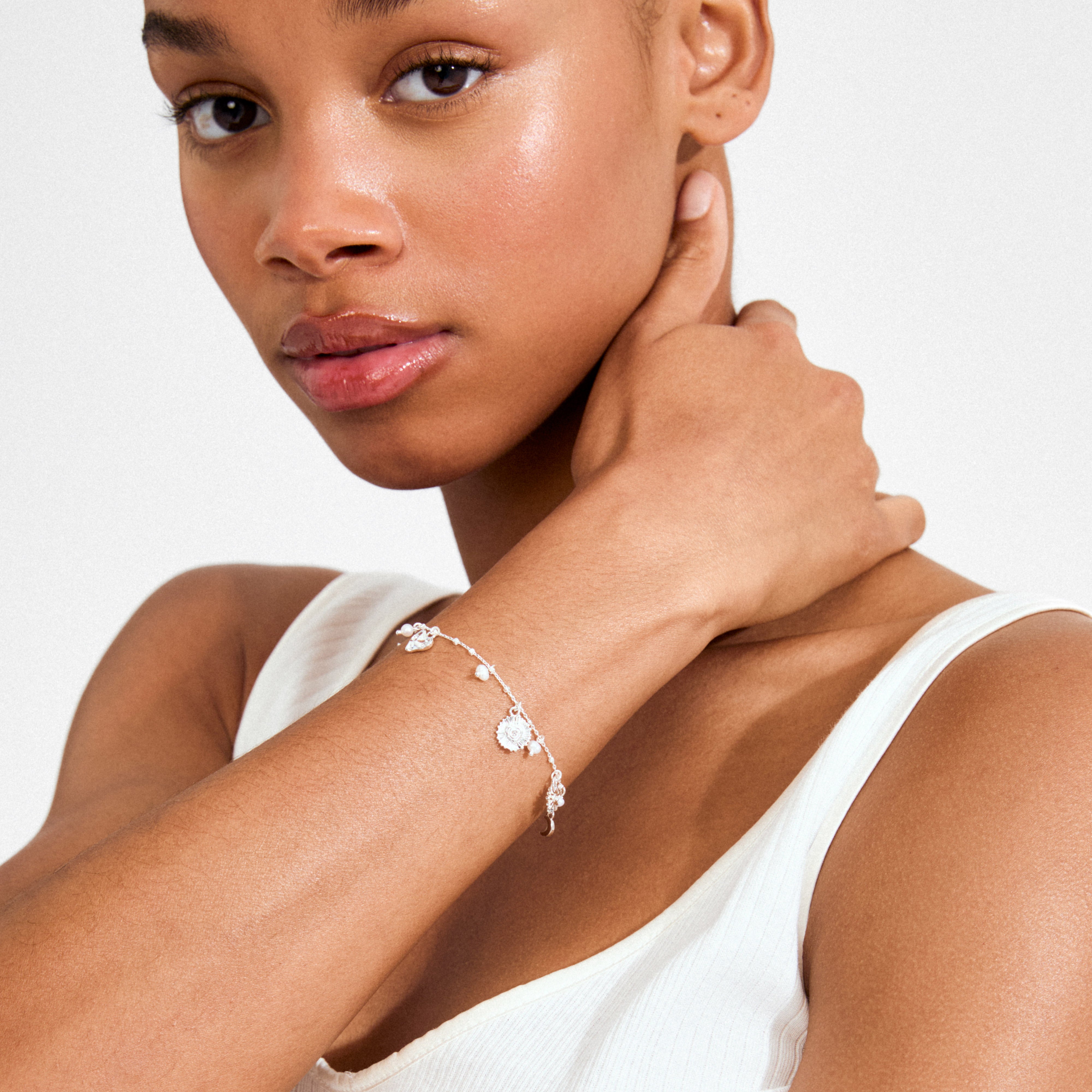 MYLAN silver-plated bracelet with charms and pearls, worn on wrist, styled in minimalist fashion, capturing Pilgrim's blend of timeless and trendy design.