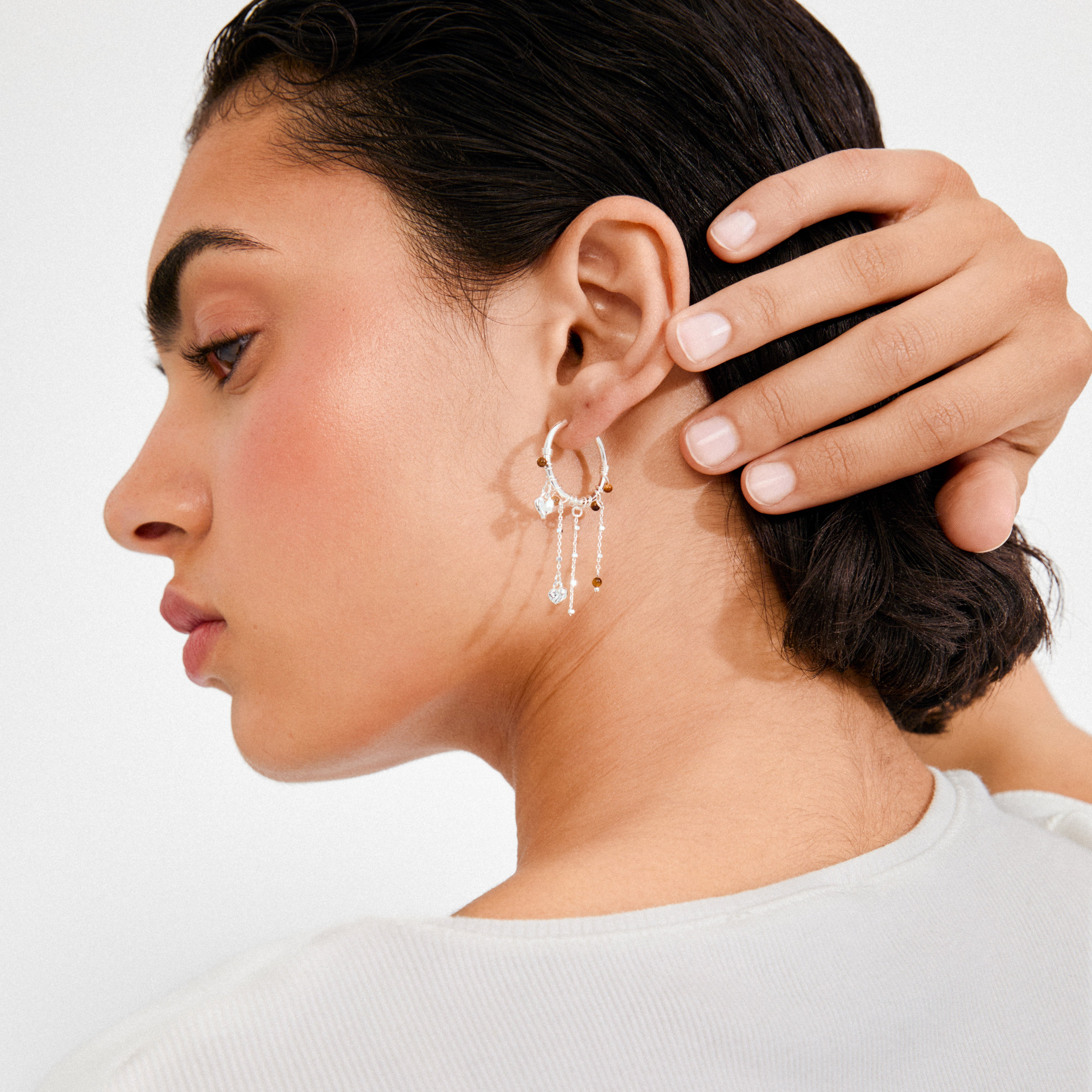 Silver-plated MYLAN earrings with dangling chains and beads on a model's ear, showcasing Pilgrim's luxe boho style with a delicate, layered design.